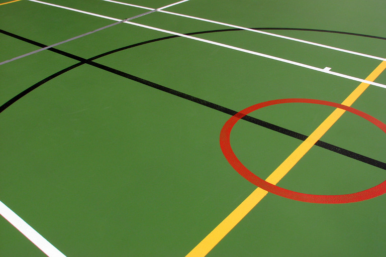 Indoor sports hall showing different floor markings, green painted.